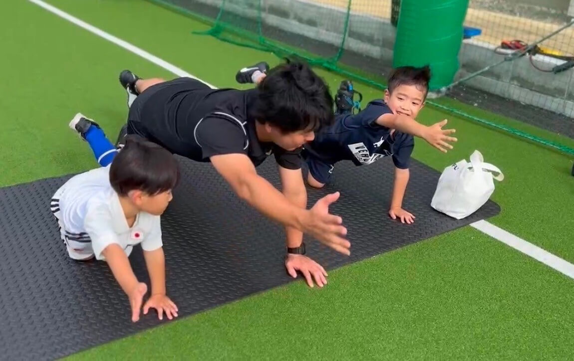 コーチの両隣に子供がいて体幹トレーニングをしている様子